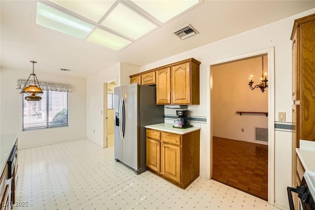 3104 Hayden Ct, Las Vegas, NV 89134 - kitchen with stainless steel refrigerator with ice dispenser, brown cabinetry, light countertops, a chandelier, and decorative light fixtures