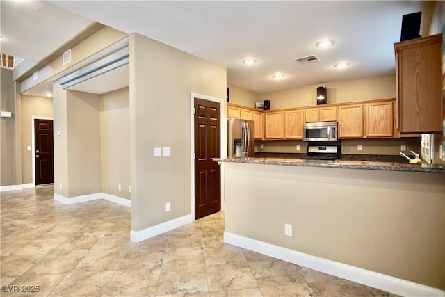 9144 Clear Sky Ave, Las Vegas, NV 89178 - kitchen featuring stainless steel appliances, dark stone countertops, a peninsula, baseboards, and recessed lighting