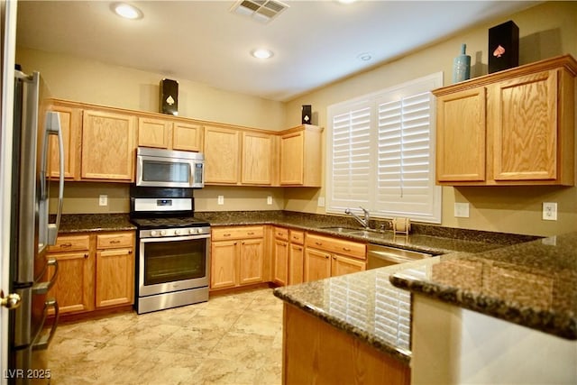 9144 Clear Sky Ave, Las Vegas, NV 89178 - kitchen with appliances with stainless steel finishes, a sink, dark stone countertops, recessed lighting, and light brown cabinets