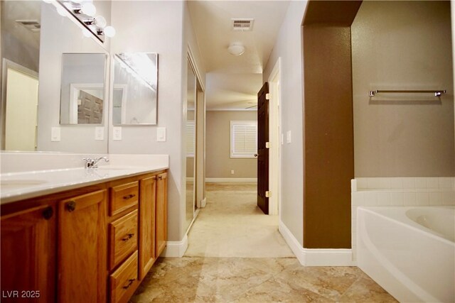 9144 Clear Sky Ave, Las Vegas, NV 89178 - full bath with double vanity, a garden tub, and baseboards