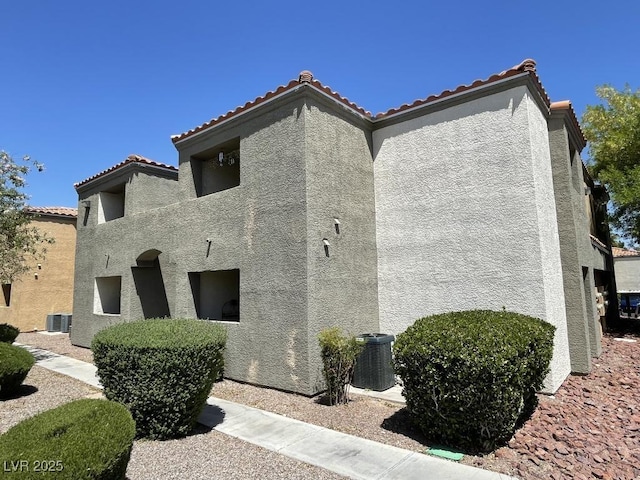 3151 Soaring Gulls Dr Unit 2147, Las Vegas, NV 89128 - view of home's exterior featuring stucco siding, a tile roof, and central AC unit