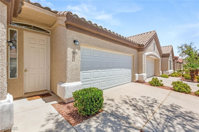 9688 Meeks Bay Ave, Las Vegas, NV 89148 - doorway to property with concrete driveway, stucco siding, a garage, and a tiled roof