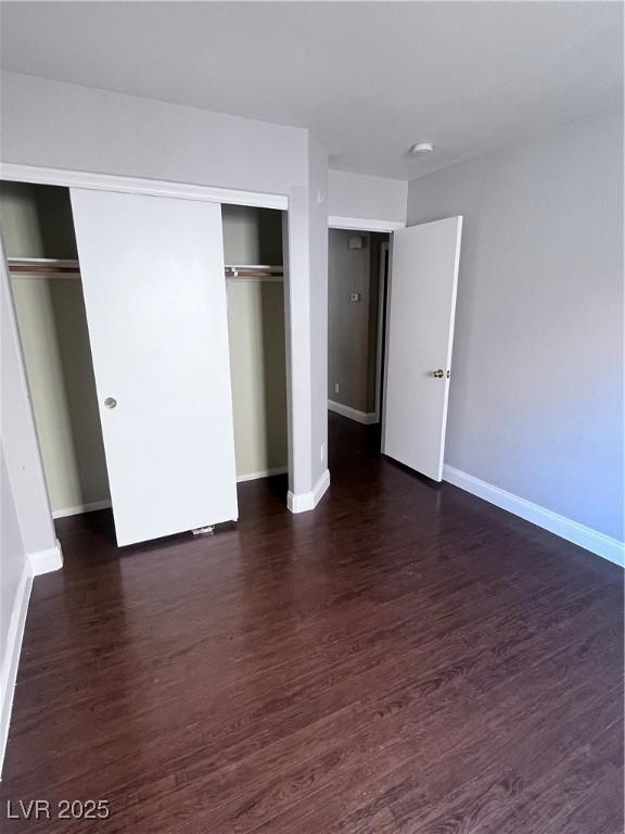 5217 Yellow Dawn Ct, Las Vegas, NV 89130 - unfurnished bedroom featuring baseboards, dark wood-type flooring, and a closet