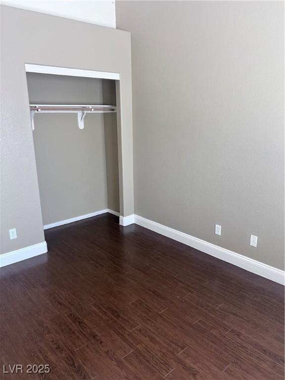 5217 Yellow Dawn Ct, Las Vegas, NV 89130 - unfurnished bedroom featuring dark wood-style floors, a closet, and baseboards