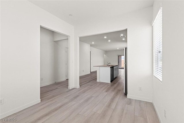 2751 Avril Point St, Las Vegas, NV 89156 - unfurnished living room featuring light wood-type flooring, a sink, recessed lighting, and baseboards