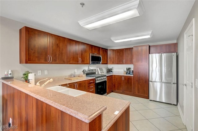 150 Las Vegas Blvd Unit 1503, Las Vegas, NV 89101 - kitchen with appliances with stainless steel finishes, a sink, brown cabinets, a peninsula, and light tile patterned floors