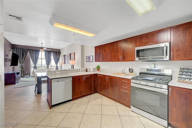 150 Las Vegas Blvd Unit 1503, Las Vegas, NV 89101 - kitchen with appliances with stainless steel finishes, light countertops, a sink, light tile patterned floors, and a peninsula