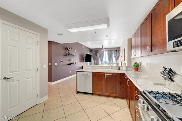 150 Las Vegas Blvd Unit 1503, Las Vegas, NV 89101 - kitchen with stainless steel appliances, a sink, a peninsula, light tile patterned floors, and ceiling fan