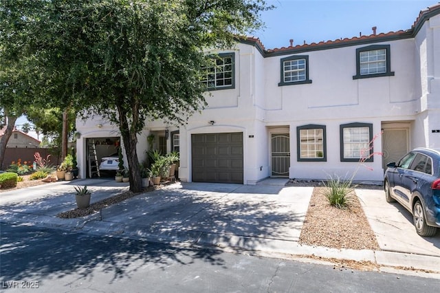 5330 E Charleston Blvd Unit 2, Las Vegas, NV 89142 - view of front of property featuring stucco siding, driveway, a tile roof, and an attached garage