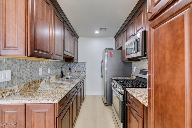 5330 E Charleston Blvd Unit 2, Las Vegas, NV 89142 - kitchen with stainless steel appliances, a sink, light wood-style floors, light stone counters, and recessed lighting