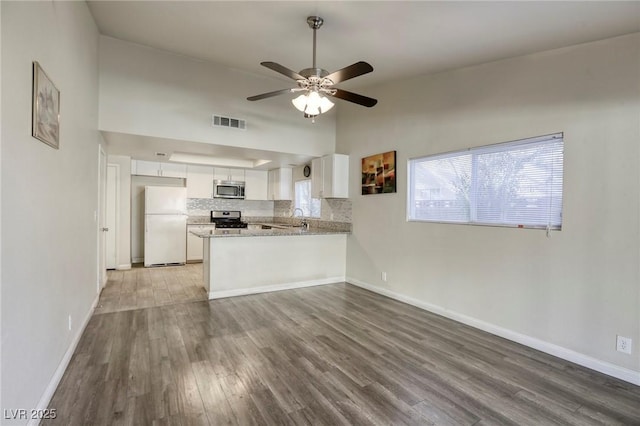 5132 Springland St, Las Vegas, NV 89146 - kitchen featuring appliances with stainless steel finishes, a sink, wood finished floors, white cabinets, and a peninsula
