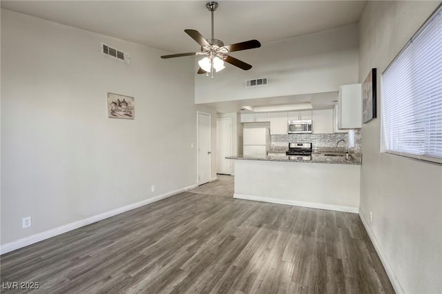 5132 Springland St, Las Vegas, NV 89146 - unfurnished living room with wood finished floors, a ceiling fan, a towering ceiling, and baseboards