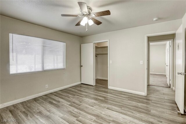 5132 Springland St, Las Vegas, NV 89146 - unfurnished bedroom with baseboards, light wood-style floors, a ceiling fan, a walk in closet, and a closet