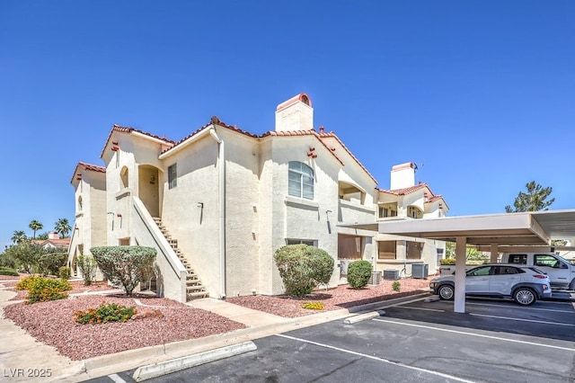 698 S Racetrack Rd Unit 1014, Henderson, NV 89015 - view of property featuring covered and uncovered parking, stairway, and central air condition unit