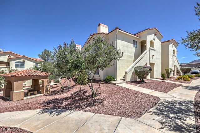 698 S Racetrack Rd Unit 1014, Henderson, NV 89015 - view of front facade featuring stairs, a tile roof, a chimney, stucco siding, and a gazebo