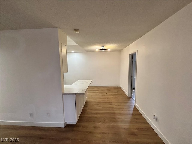5920 Glen Eagles Ln, Las Vegas, NV 89108 - hallway with baseboards, a textured ceiling, and dark wood-type flooring