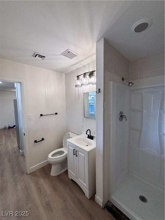 5920 Glen Eagles Ln, Las Vegas, NV 89108 - bathroom with wood finished floors, a shower, vanity, toilet, and baseboards