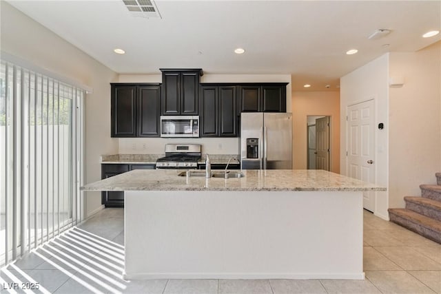 4566 Mansart Ct Unit 1104, North Las Vegas, NV 89031 - kitchen with stainless steel appliances, a sink, a kitchen island with sink, light stone counters, and recessed lighting