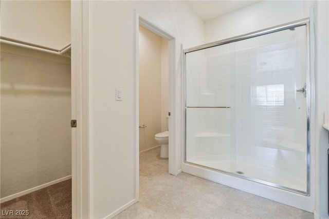 4566 Mansart Ct Unit 1104, North Las Vegas, NV 89031 - bathroom featuring a stall shower, toilet, a walk in closet, and baseboards