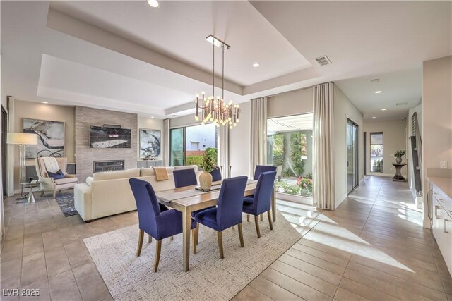 10 Sugarberry Ln, Las Vegas, NV 89135 - dining area featuring a tray ceiling, a large fireplace, a chandelier, light tile patterned floors, and recessed lighting