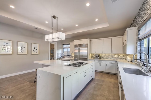 10 Sugarberry Ln, Las Vegas, NV 89135 - kitchen featuring stainless steel appliances, a sink, tasteful backsplash, a kitchen island, and a raised ceiling