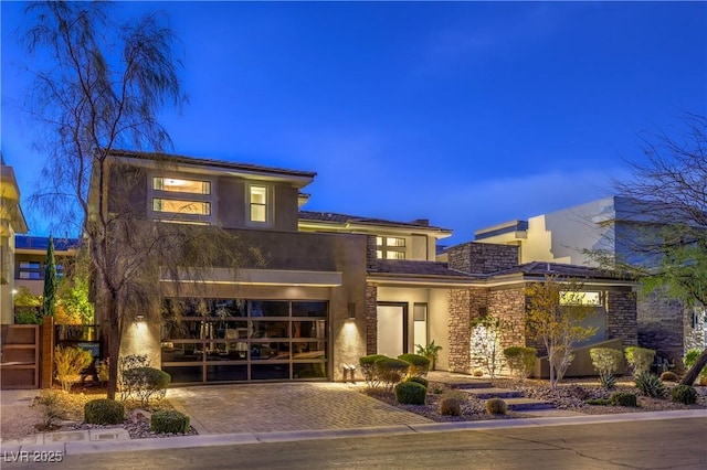 10 Sugarberry Ln, Las Vegas, NV 89135 - view of front facade with decorative driveway, a garage, stone siding, stucco siding, and a chimney