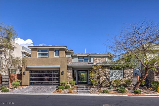 10 Sugarberry Ln, Las Vegas, NV 89135 - view of front facade with stone siding, stucco siding, a garage, and decorative driveway