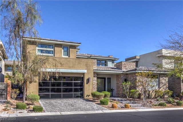 10 Sugarberry Ln, Las Vegas, NV 89135 - view of front of house featuring an attached garage, stucco siding, decorative driveway, and stone siding