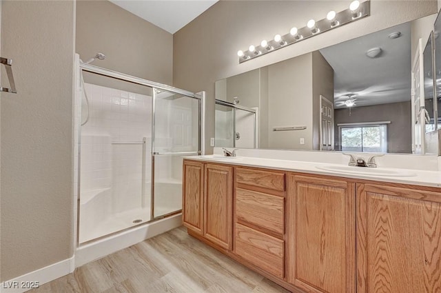 9303 Gilcrease Ave Unit 2217, Las Vegas, NV 89149 - bathroom with a stall shower, double vanity, wood finished floors, and ceiling fan