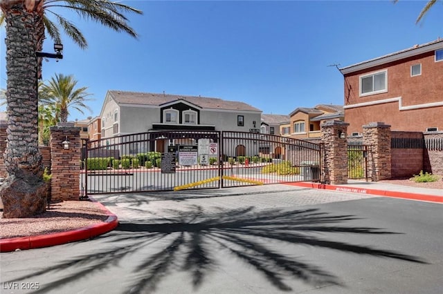 9303 Gilcrease Ave Unit 2217, Las Vegas, NV 89149 - view of asphalt road featuring a gate, curbs, a residential view, and a gated entry