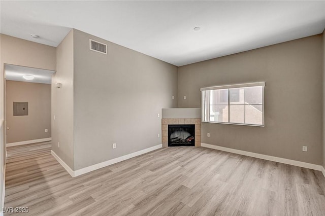 9303 Gilcrease Ave Unit 2217, Las Vegas, NV 89149 - unfurnished living room featuring light wood-style floors, baseboards, and a tile fireplace