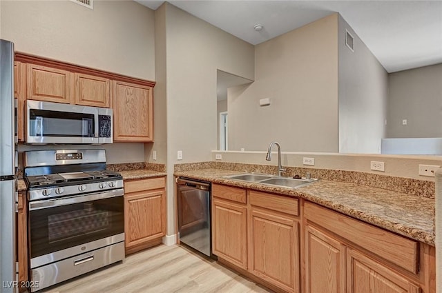9303 Gilcrease Ave Unit 2217, Las Vegas, NV 89149 - kitchen with stainless steel appliances, a sink, and light wood finished floors