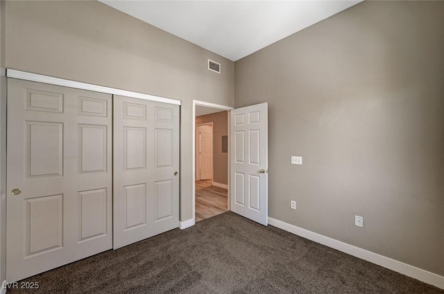 9303 Gilcrease Ave Unit 2217, Las Vegas, NV 89149 - unfurnished bedroom with dark carpet, baseboards, and a closet