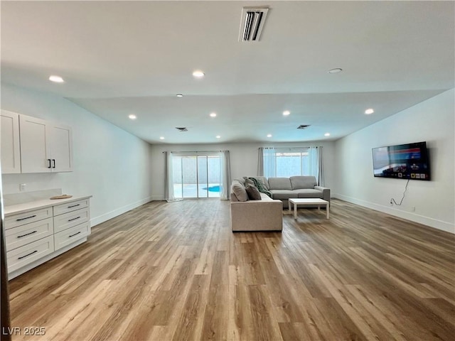 6191 Bullion Blvd, Las Vegas, NV 89103 - living room featuring baseboards, light wood finished floors, vaulted ceiling, and recessed lighting