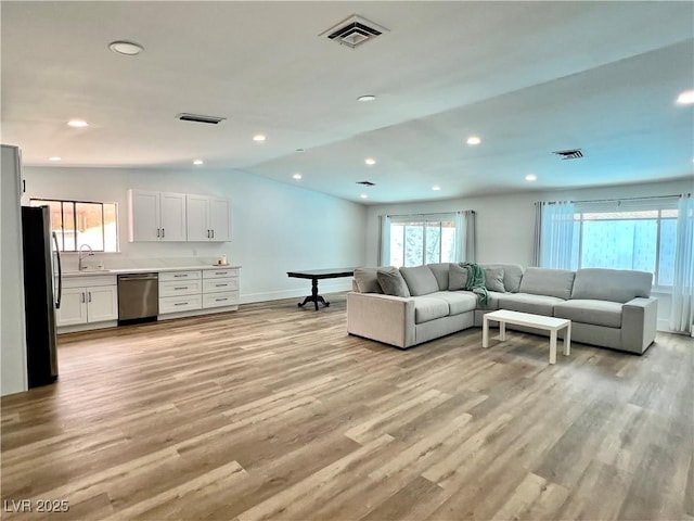 6191 Bullion Blvd, Las Vegas, NV 89103 - living area featuring light wood-type flooring, lofted ceiling, baseboards, and recessed lighting