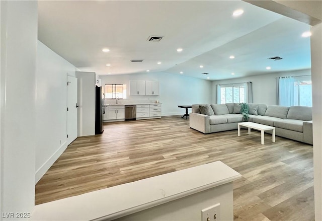 6191 Bullion Blvd, Las Vegas, NV 89103 - living room featuring light wood-style flooring, vaulted ceiling, recessed lighting, and baseboards