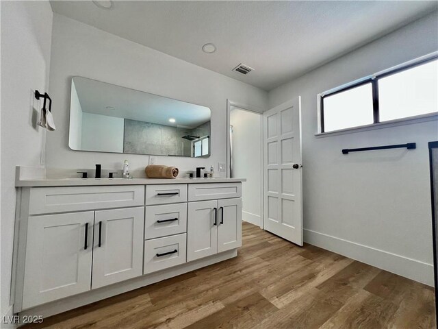 6191 Bullion Blvd, Las Vegas, NV 89103 - full bath with double vanity, tiled shower, wood finished floors, and baseboards