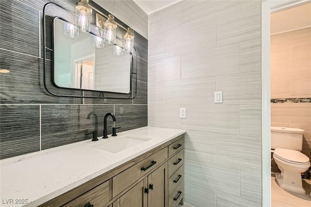 6309 Miraloma St, Las Vegas, NV 89108 - bathroom featuring toilet, vanity, tasteful backsplash, and tile walls
