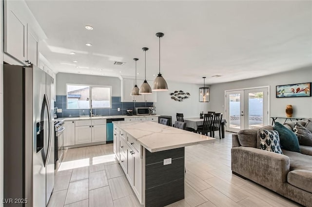 6309 Miraloma St, Las Vegas, NV 89108 - kitchen featuring stainless steel appliances, open floor plan, plenty of natural light, decorative backsplash, and recessed lighting