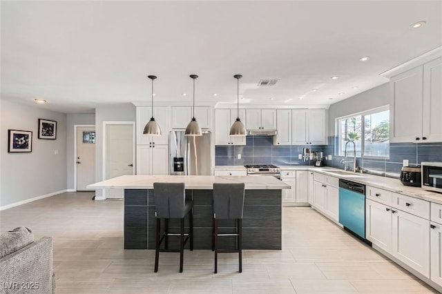 6309 Miraloma St, Las Vegas, NV 89108 - kitchen featuring stainless steel appliances, a sink, backsplash, a kitchen island, and recessed lighting