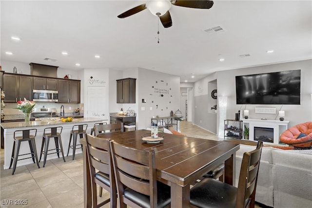 2169 Rio Rancho Pointe Pl, Henderson, NV 89002 - dining room featuring ceiling fan, a fireplace, light tile patterned flooring, and recessed lighting