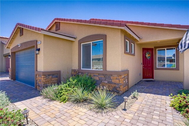 2169 Rio Rancho Pointe Pl, Henderson, NV 89002 - view of front of property with an attached garage, stone siding, and stucco siding