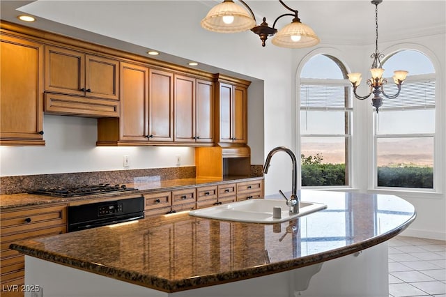 12 Strada Di Circolo -, Unit Henderson, NV 89011 - kitchen featuring oven, a chandelier, brown cabinets, a sink, and a kitchen island with sink