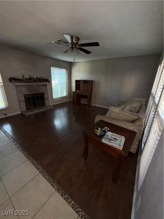 6521 Sugarpine Ln, Las Vegas, NV 89107 - living area with a fireplace, tile patterned flooring, a ceiling fan, baseboards, and inlaid floor details