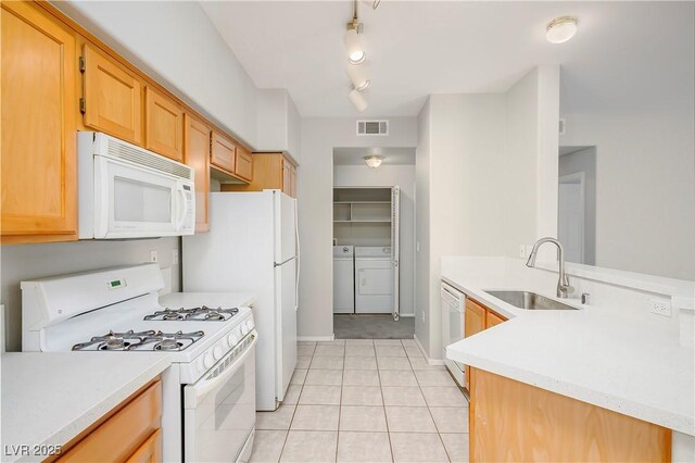 8501 W University Ave Unit 2020, Las Vegas, NV 89147 - kitchen featuring white appliances, a sink, washer and dryer, light countertops, and a peninsula