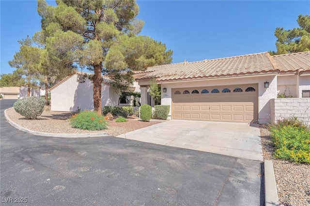 1951 Moyer Dr, Henderson, NV 89074 - view of front of home featuring concrete driveway, stucco siding, a tiled roof, and an attached garage