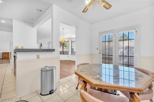 1951 Moyer Dr, Henderson, NV 89074 - dining area with wainscoting, a chandelier, a ceiling fan, light tile patterned flooring, and wooden walls