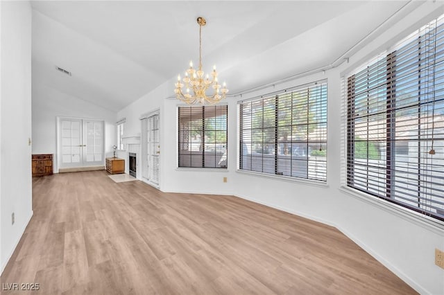 1951 Moyer Dr, Henderson, NV 89074 - unfurnished living room with a chandelier, healthy amount of natural light, light wood-style flooring, lofted ceiling, and baseboards