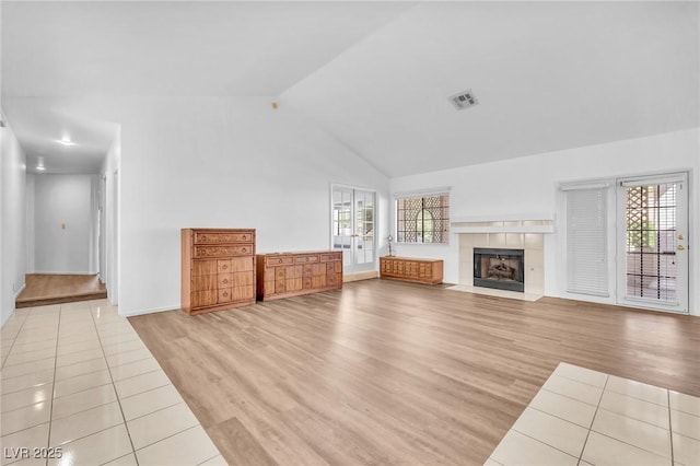 1951 Moyer Dr, Henderson, NV 89074 - unfurnished living room featuring high vaulted ceiling, wood finished floors, plenty of natural light, and a tile fireplace