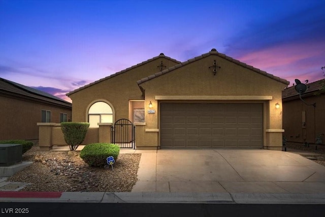 4062 Vulcan St, Las Vegas, NV 89122 - view of front of home with an attached garage, stucco siding, concrete driveway, a tiled roof, and a gate